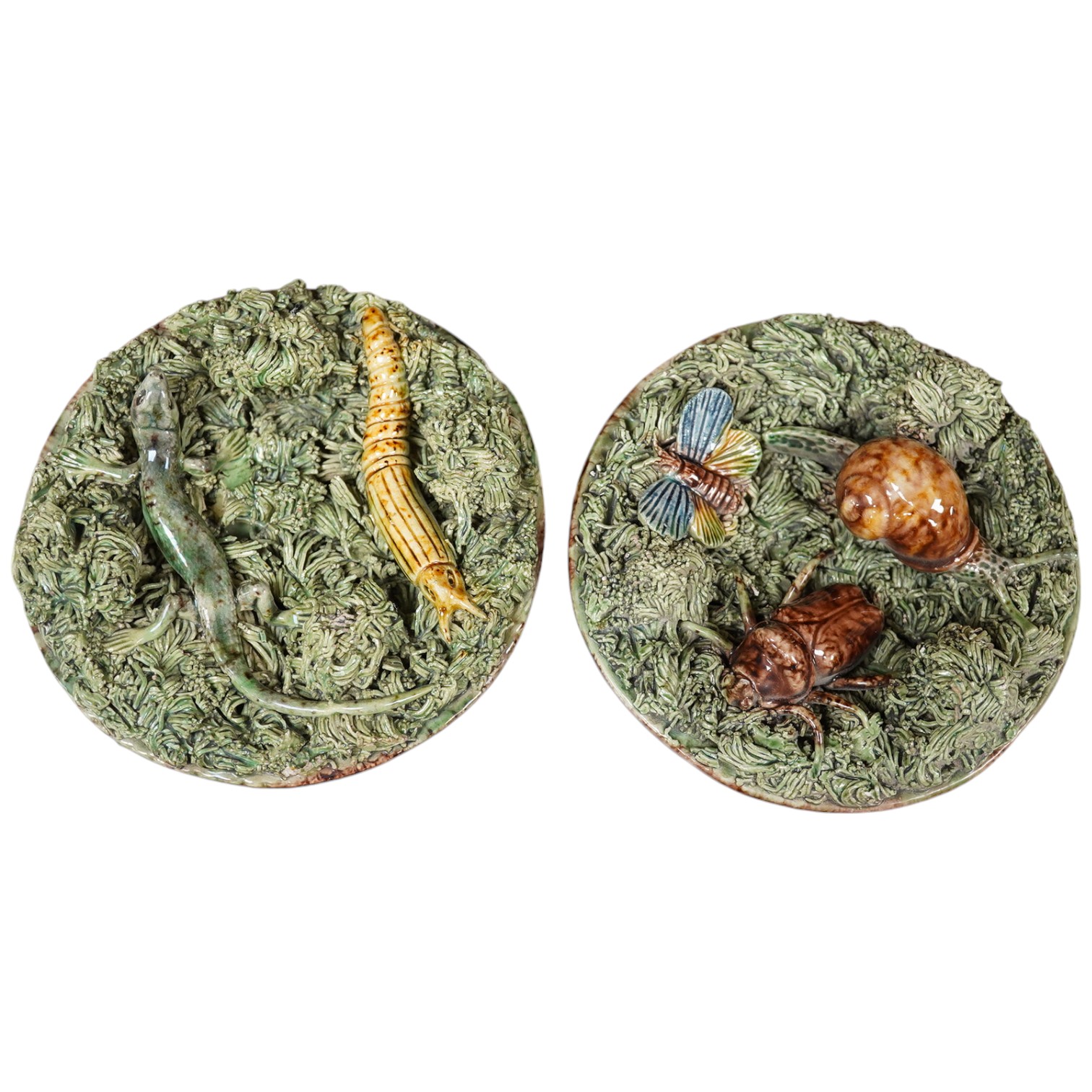 A pair of late 19th century Portuguese small circular Palissy style majolica plaques incorporating lizard and snail and with a mossy ground, impressed marks to reverse, 12cm diameter. Condition - fair